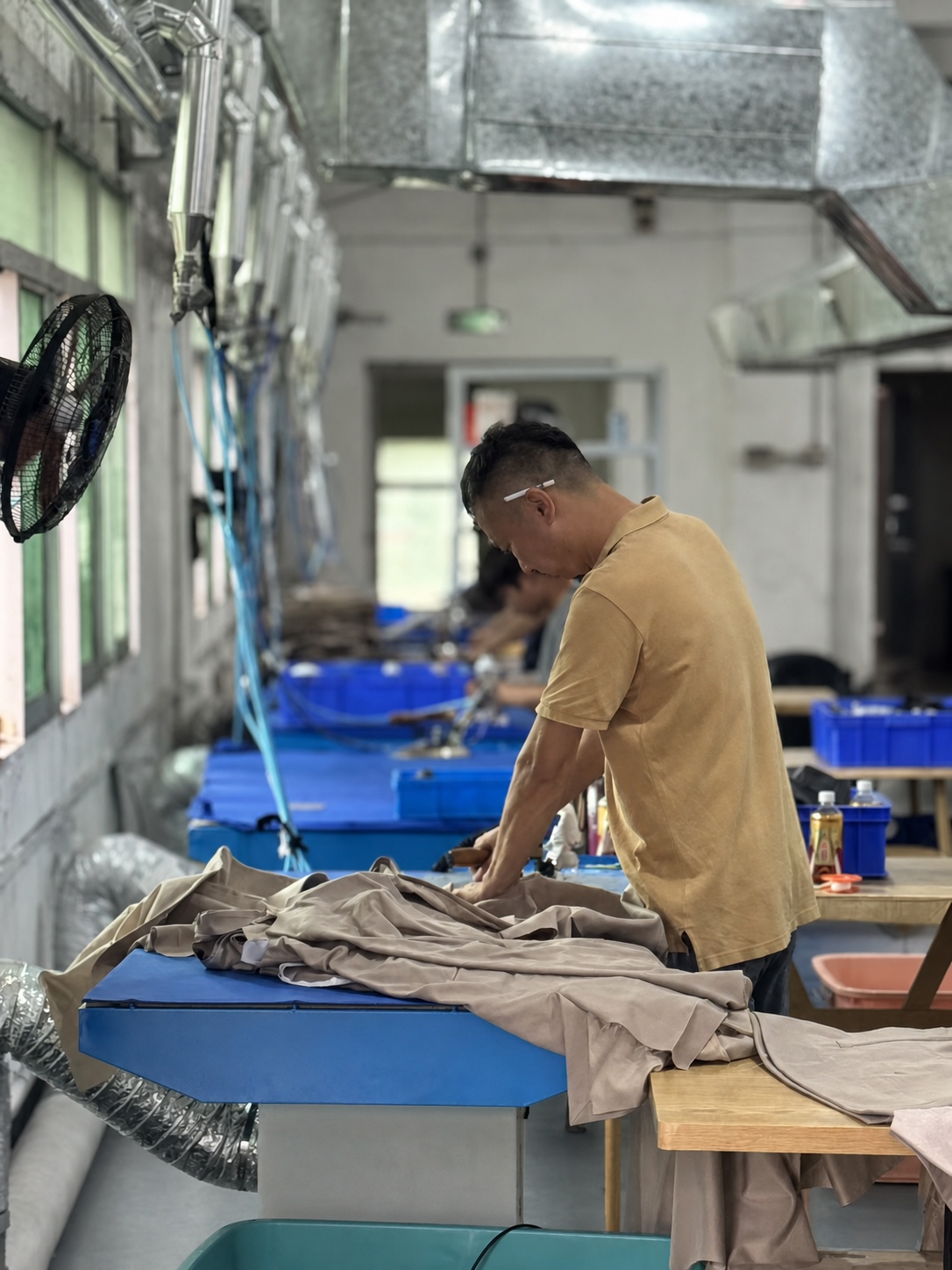 Pressing worker preparing uniform suit presentation before delivery